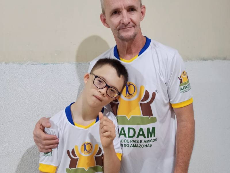 Pai com o filho vestidos com a camisa da APADAM